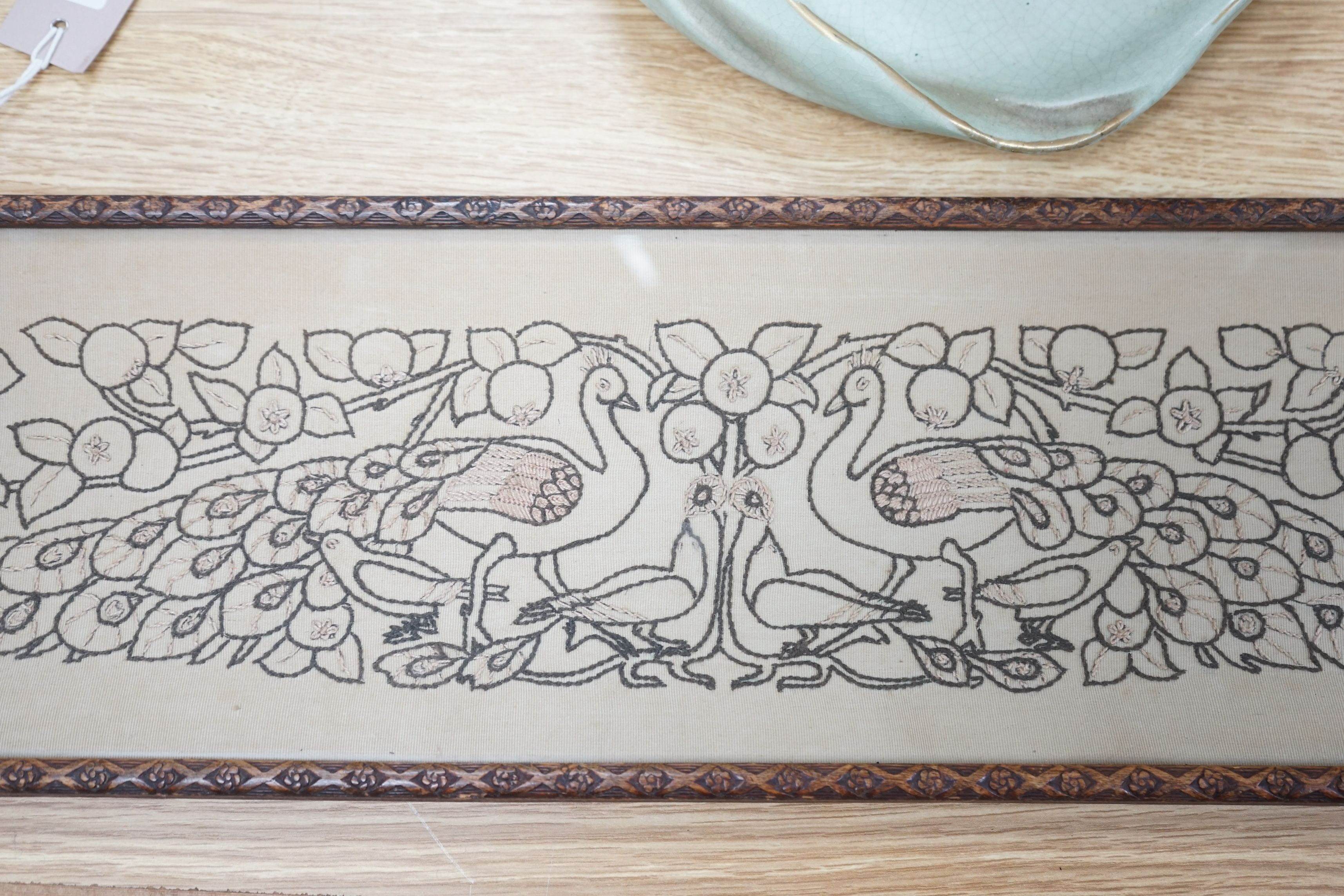 An Arts & Crafts peacock framed embroidered panel, 15.5cms high x 54.5cms wide
